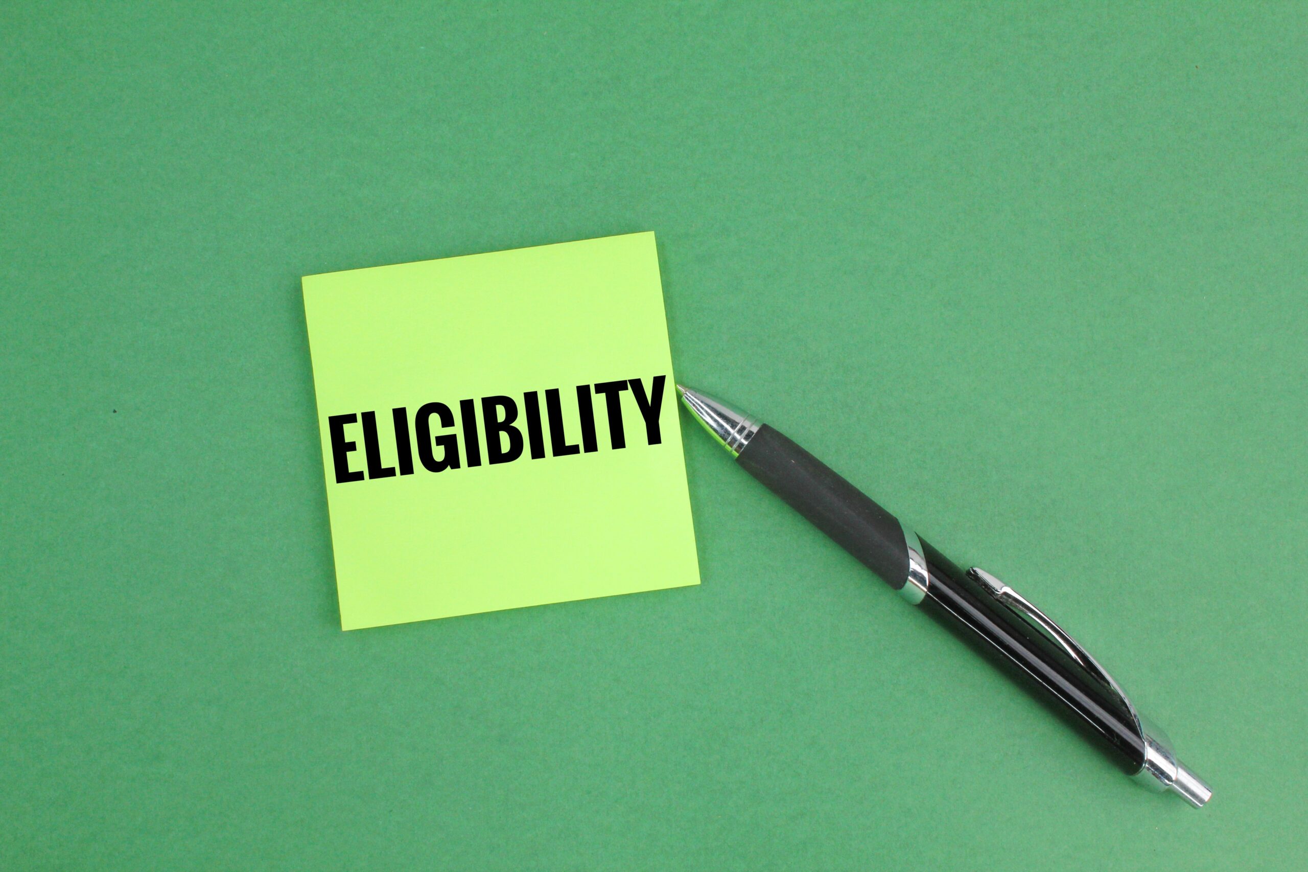 Bright green sticky note with the word “ELIGIBILITY” next to a black pen on a green background, representing Global Talent Visa eligibility in 2025.