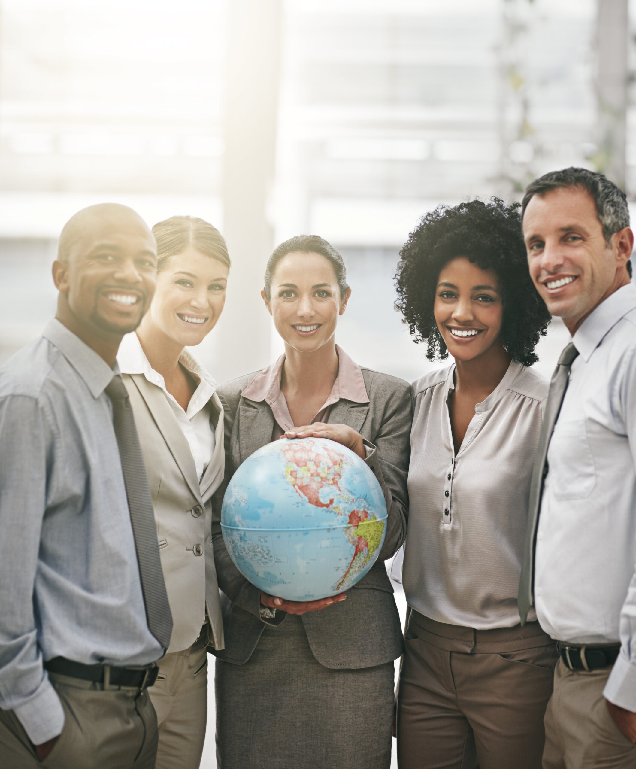 A diverse group of professionals standing together, with one holding a globe, symbolising international talent and global opportunities.